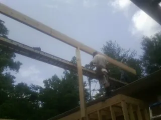 Carpenter setting a ridge beam over a new addition frame — Ice Dam Removal by Roofing Brothers in Noxen