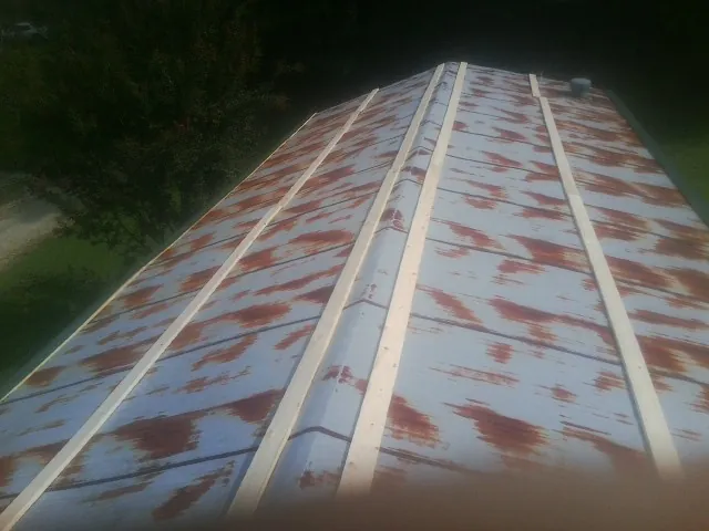 Rusted metal roof panels with new wood purlins before replacement — Storm Damage Roof Repair in Noxen by Roofing Brothers