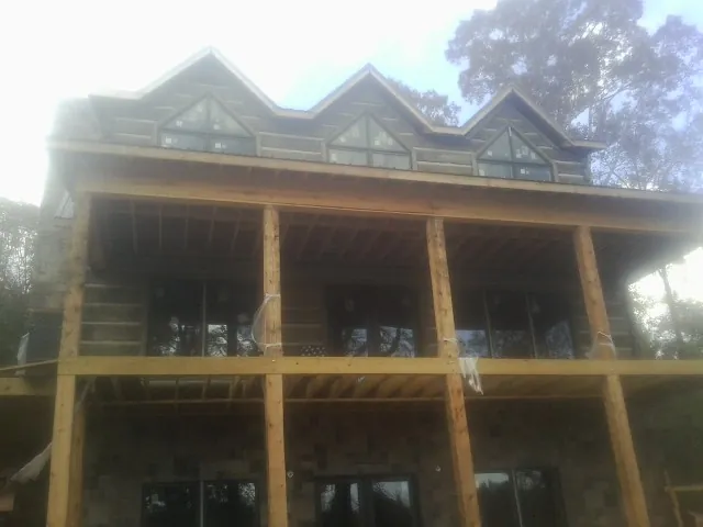 Dormers and porch framing on a large log home under construction — Roof Coating work by our crew in Noxen