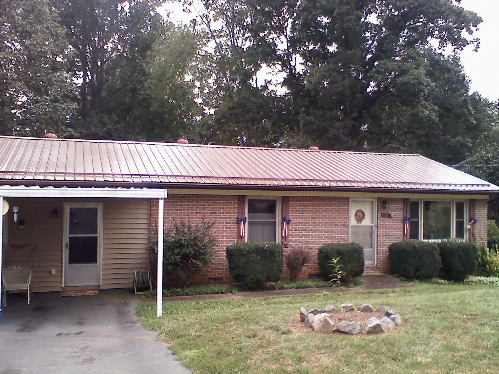 Bronze metal roof and carport on a brick ranch home — Roof Repair work by our crew in Noxen